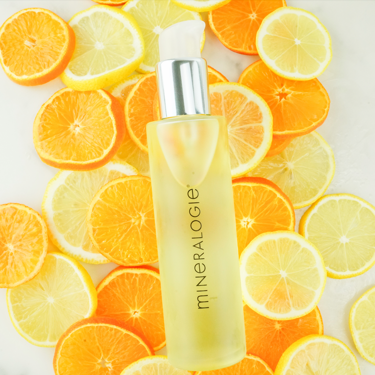 Halo Body Oil on top of lemons and tangerines