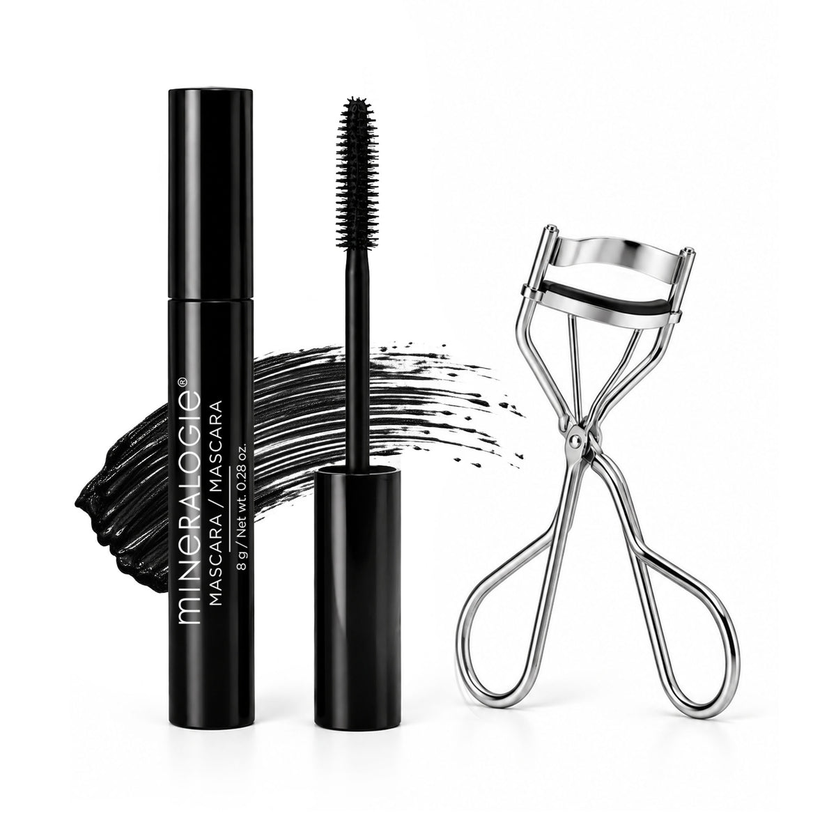 MINERALOGIE  mascara in a sleek black tube with the wand removed, shown beside a silver eyelash clamp and a black mascara swatch on a clean white background.