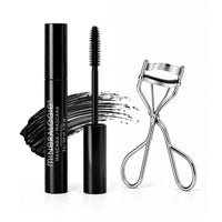 MINERALOGIE  mascara in a sleek black tube with the wand removed, shown beside a silver eyelash clamp and a black mascara swatch on a clean white background.