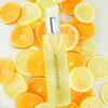 Halo Body Oil on top of lemons and tangerines